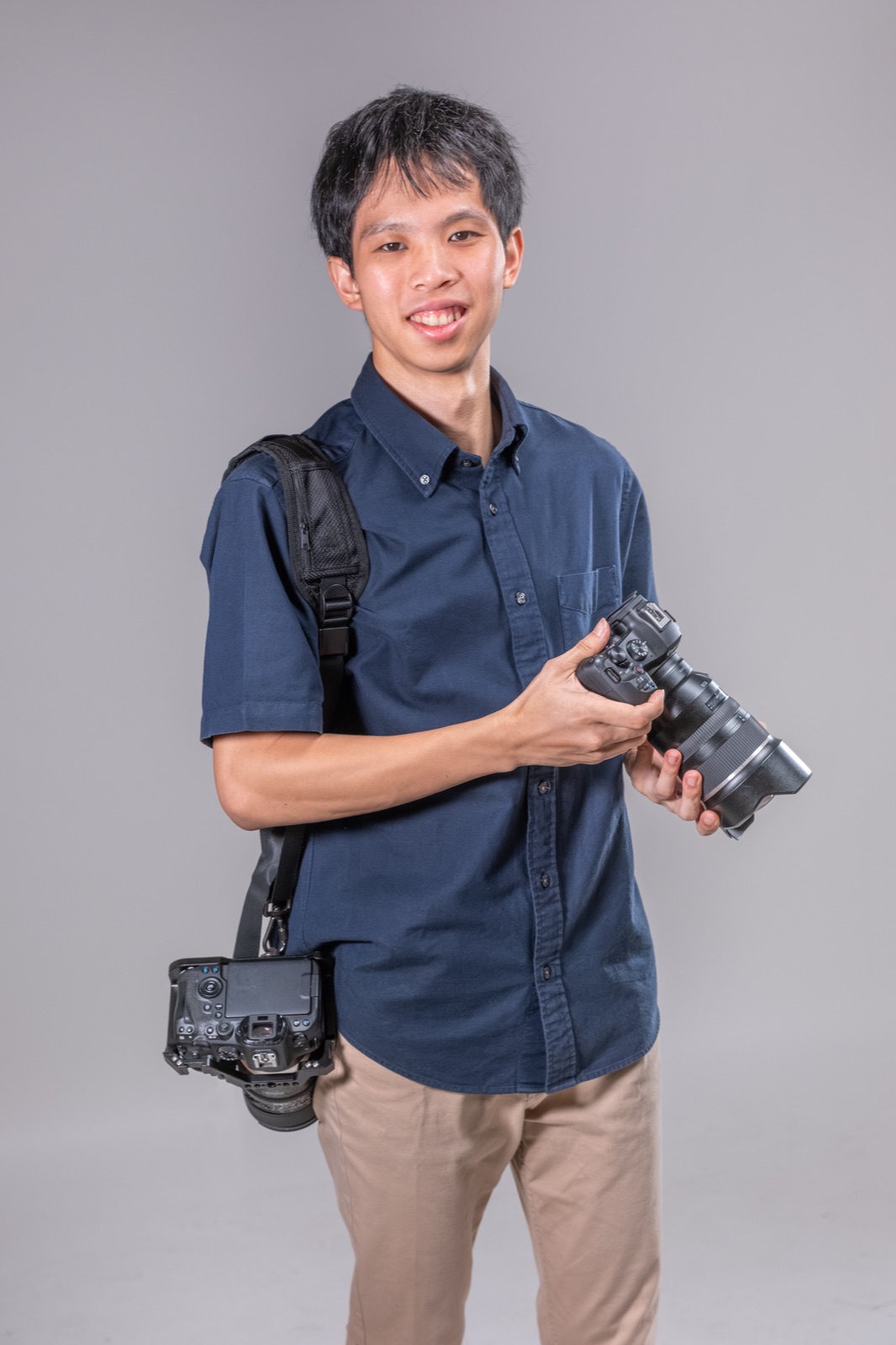 Asher smiling, holding a camera